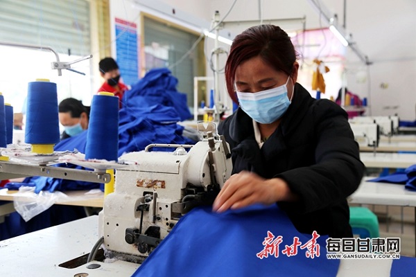西峰区什社乡李岭村扶贫车间工人赶制服装。.jpg