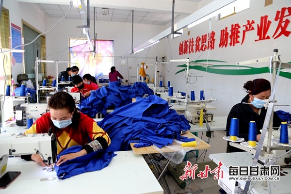 西峰区什社乡李岭村扶贫车间工人赶制服装.jpg