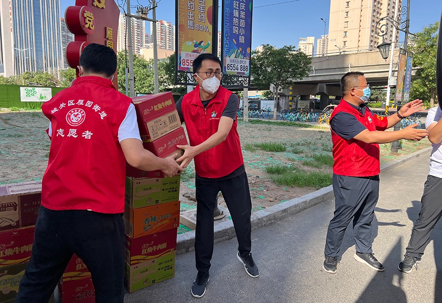 省高院下沉社区干部在值守的小区内搬运生活物资。